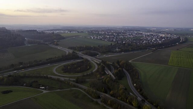 Traffic on hightway junction in dusk near a village aerial time lapse