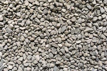 Batu split coffee shop. Grey ballast stone surface. Texture of ballast rock bed. Floor covered by gray rocks small pebble materials.