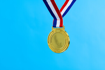Blank gold medal on blue background