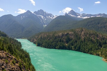 River with turquoise water passing between mountains with tall trees in Cascades National Park
