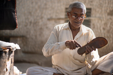 A cobbler repairing shoes on the streets of Delhi