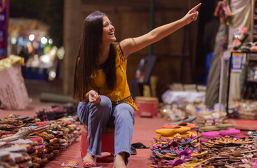 Cheerful woman shopping sandals from street shop