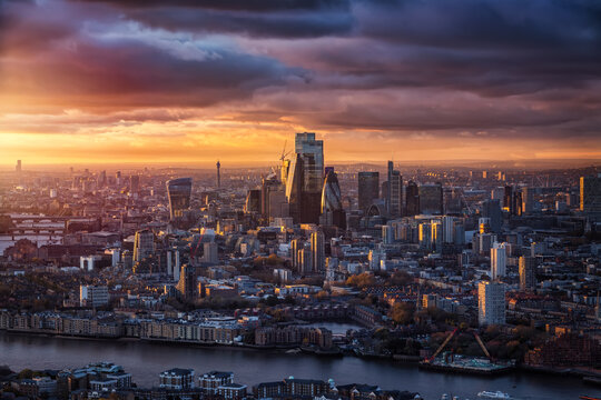The skyline of the City of London with the modern office skyscrapers reflecting the warm sunlight of a cloudy winter sunset, England © moofushi