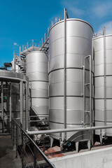 Steel tanks for wine fermentation at a modern winery. Large brewery silos for barley or beer