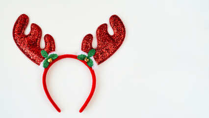 Closeup of red shiny christmas horns on white background,decorative headband,top view,flat lay,copy space.Decor concept for christmas or new year party.Christmas antlers.