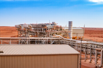 Inlet gas compression in oil gas industry under a blue sky in Algerian desert 