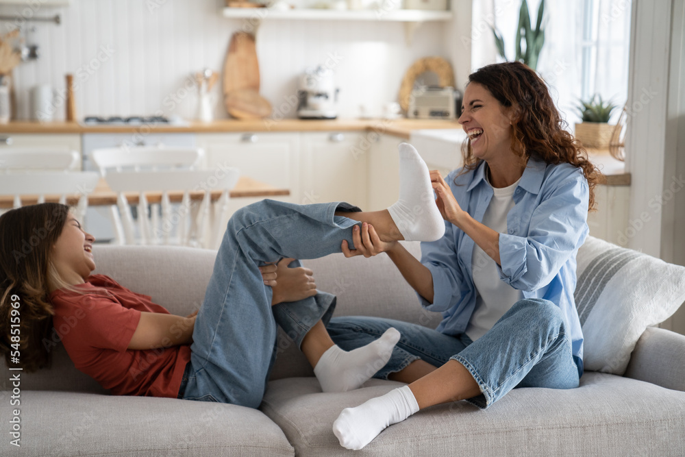 Wall mural laughing mom and daughter have fun as best friends spending time together for happy family life. joy