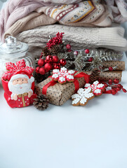Obraz na płótnie Canvas Christmas holiday background. Santa Claus cup, gift box, Christmas cookies, sweaters close up. festive winter season. 