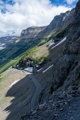 Scenic vertical view of the mountain road in Glacier National Park on a sunny day