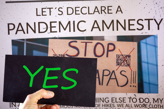 Symbolic image Pandemic Amnesty: Cut-out of a symbolic newspaper, a sign with the inscription YES is held in front of it. The photo in the background of the image is by the compositor himself