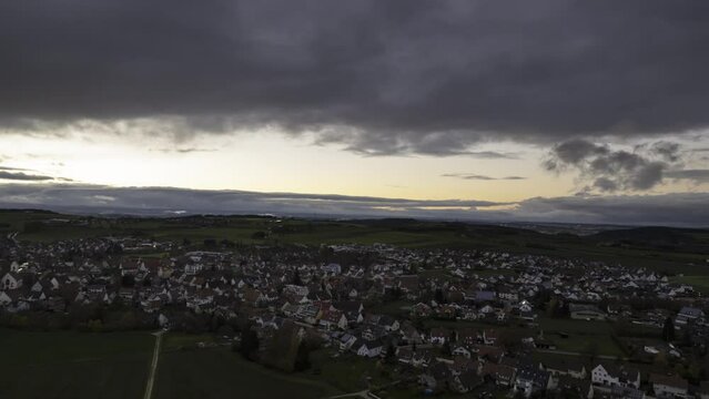 Village while dawn under dark clouds aerial time lapse