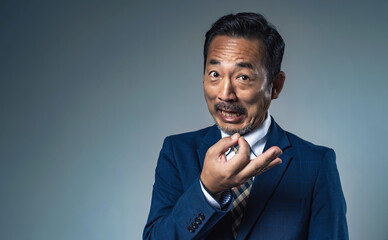 お金のハンドサインを見せる怪しいビジネスマン