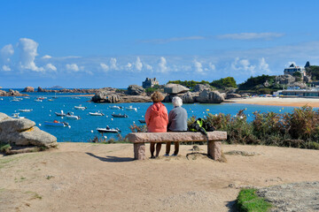 Deux personnes assises sur un banc face  à la mer à Trégastel en Bretagne