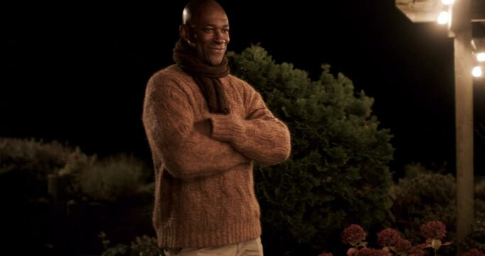 Smiling man standing in backyard at night