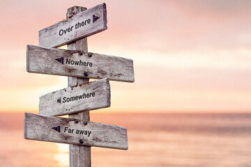 over there nowhere somewhere far away text written on wooden signpost outdoors at the beach during sunset
