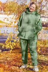 Mature woman in a green sweatshirt on a walk in the autumn park. Digital detox,.