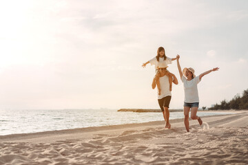 Fototapeta na wymiar Happy asian family enjoy the sea beach at consisting father, mother and daughter having fun playing beach in summer vacation on the ocean beach. Happy family with vacations time lifestyle concept.