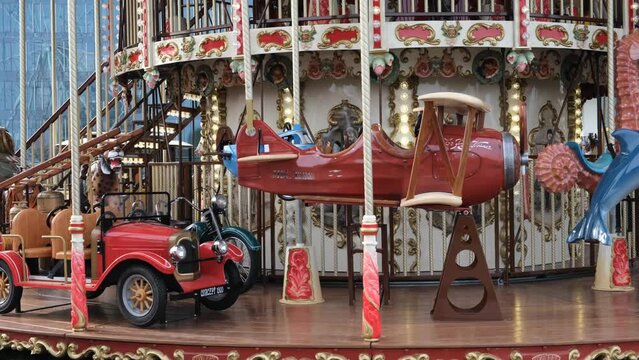 The merry-go-round at the amusement park is spinning and sparkling with lights. Video 4k.