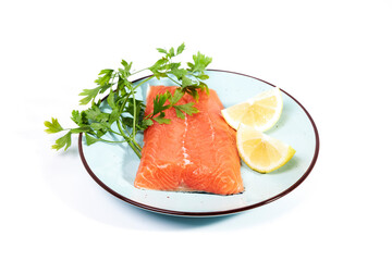 Salmon, fresh raw fish fillets together with parsley and lemon on a plate