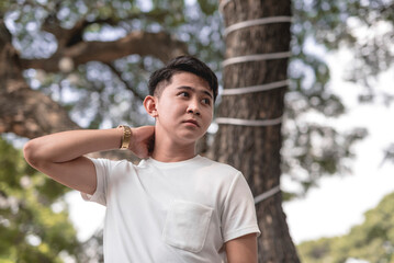 A picture of a Filipino guy with a serious expression looking sideways and holding his neck while wondering about what the future could bring him.