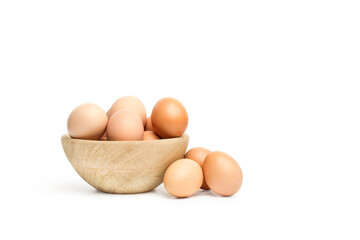 Huevos de gallina marrones dentro de un cuenco de madera rustico sobre un fondo blanco liso y aislado. Vista de frente y de cerca. Copy space