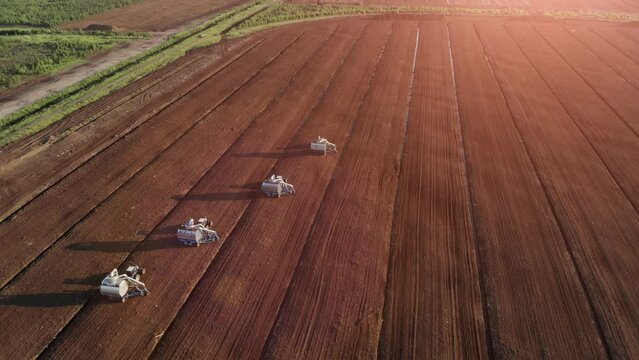 Drone shooting. Harvesting peat with combines. Peat extraction process. Agriculture industry.
