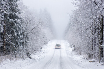 Car driving on a slippery road in a winter forest