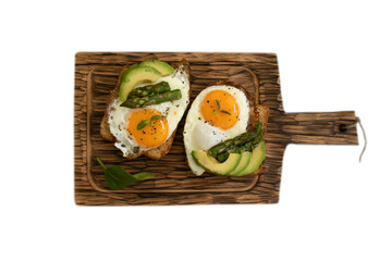 Sandwich with fried egg, asparagus on wooden board isolated