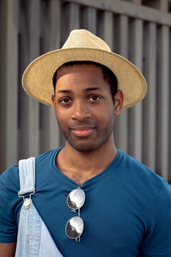 Portrait of a coloured man wearing a straw hat and looking at the camera. 