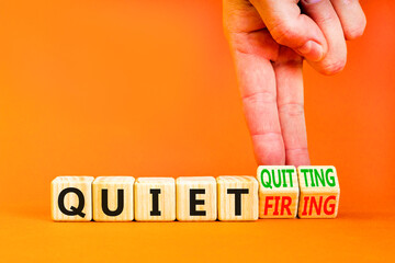 Quiet quitting or firing symbol. Concept words Quiet quitting Quiet firing on cubes. Businessman hand. Beautiful orange table orange background. Business quiet quitting or firing concept. Copy space.