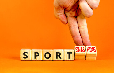 Sport or sportswashing symbol. Concept words Sport and Sportswashing on wooden cubes. Businessman hand. Beautiful orange table orange background. Business sport sportswashing concept. Copy space.