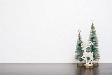 Christmas New Year still life with XMAS trees and deer at home interior. Copy space.