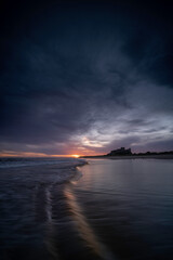 Naklejka premium Bamburgh castle viewed at sunrise, located on the northumberland coastline.