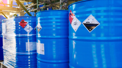Flammable, acid, volatile, warning labels, mounted on hazardous chemical storage tanks in the warehouse of a chemical industrial factory plant. Waiting for delivery according to the user's order. - obrazy, fototapety, plakaty