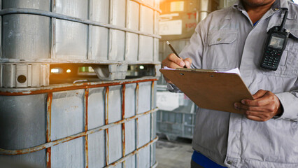 Quality inspectors are standing, check and record the quality and quantity of barrels chemical...