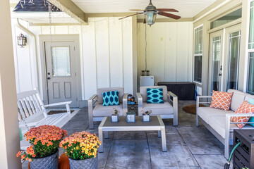 Covered outdoor patio in a new construction house home with guest seating
