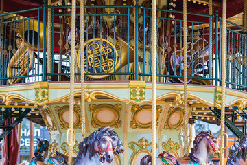 Children's carousel with musical instruments on the second floor in retro style. A fragment of a multi-colored vintage carousel in the park.