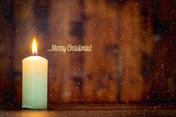 Merry Christmas.Candle lit in a rustic atmosphere and snow effect