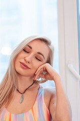 Portrait of pretty blonde girl in colorful hippie top with bohemian accessories