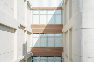 The corridors between buildings are provided with full height windows with white curtains.