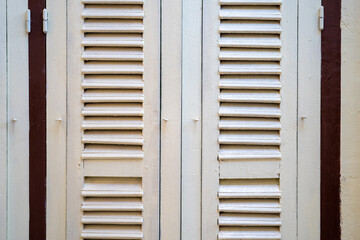 Fototapeta premium Closing white wooden vintage door in Thailand with cement white creamy colour wall beside it.