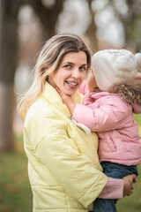 Portrait of a beautiful charming young mother with her daughter in the spring park.