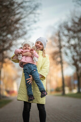 Portrait of a beautiful charming young mother with her daughter in the spring park.