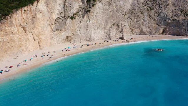 Aerial drone video of popular paradise deep turquoise beach of Porto Katsiki with white steep rocky seascape and beautiful cloudy landscape, Lefkada island, Ionian, Greece