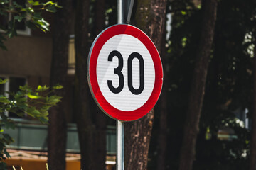 30 speed limit round traffic road sign with red ring in an urban area
