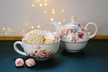 New Year's dinner with tea and zephyrs. Christmas lights background