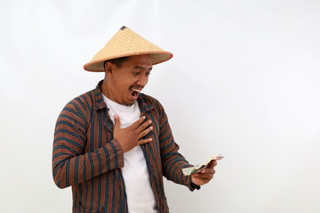 Surprised asian farmer standing while holding a cell phone. Isolated on white background with copyspace