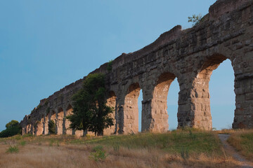 Ancient aqueducts at Parco Degli Acquedotti, a public Aqueduct Park in Rome, Italy. Stone arches built to bring water into the city during the Roman Empire. Ruins of an engineering feat.
