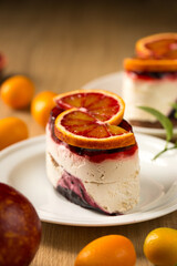 Panna cotta dessert with berry jelly and red orange, close-up