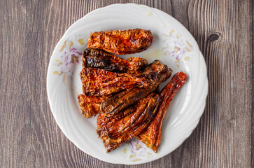 Dry hot pepper fries on wooden background.